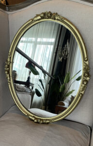 Oval mirror in a carved wooden gold-tone frame